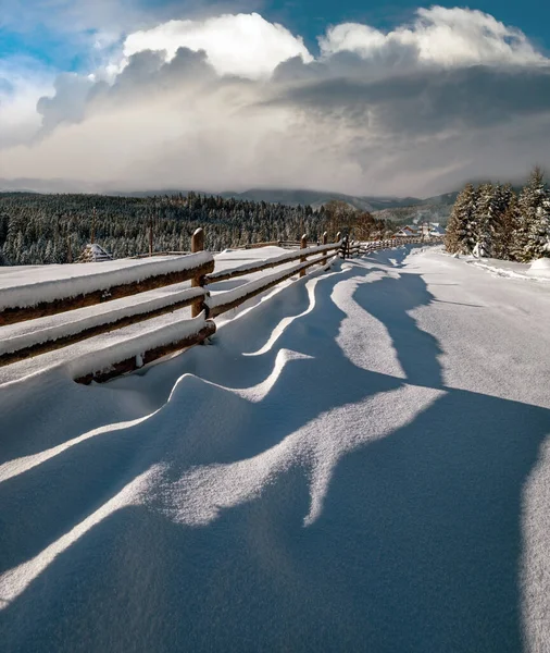 风景如画的影子在雪地上从木栅栏上飘扬 高山冬季小村子郊外 雪地小径 冷杉林 分辨率高 场深度大的图像 — 图库照片