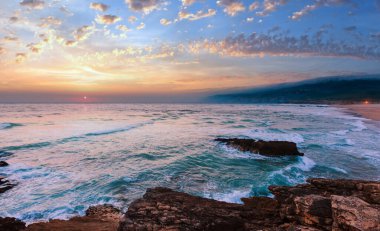 Gün batımı yaz Atlantik Okyanusu kayalık sahil kumlu plajı (Guincho, Portekiz ile).