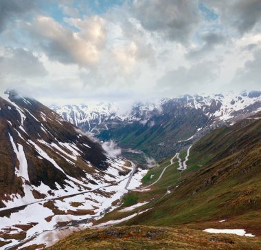Karayolu ile yaz bulutlu dağ manzarası (Furka Pass, İsviçre)