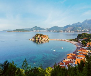 Sveti Stefan deniz adacık pembe plaj (Karadağ, Budva yakınındaki) ile sabah görünümü. Tanınmayan insanlar.