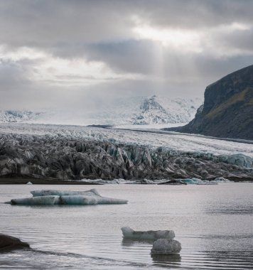 Skaftafellsjokull Buzulu, İzlanda. Buzul dili, buzul altı Esjufjoll volkanı yakınlarındaki Vatnajokull buzulundan veya Vatna Buzulu 'ndan kayar. Buzul gölü, buz blokları ve dağlarla çevrili..