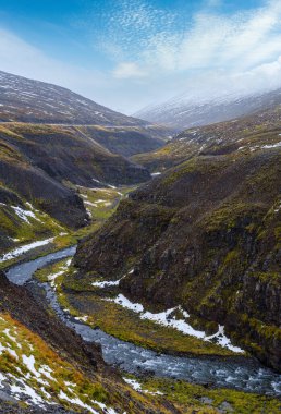 İzlanda 'nın kuzeyinde sonbahar bulutlu bir gün. Güzel kanyondan akan küçük bir nehir.