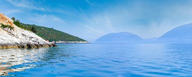 Yaz sahil görünümü üzerinden motorbot (kefalonia yakınındaki agia effimia, Yunanistan) ve sağ ithaka adada. Panorama.