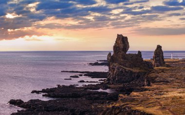 Batı İzlanda, Snaefellsnes yarımadası, Snaefellsjokull Ulusal Parkı, Londrangar Manzara Noktası 'ndaki araba gezisine bakın. Muhteşem siyah volkanik kayalık okyanus kıyıları, kayalıklardaki tarihi volkanik kuleler.