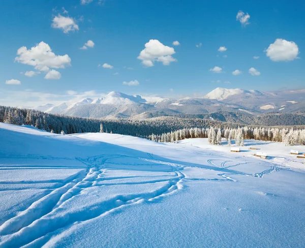 Winter calm mountain landscape with sheds group and mount ridge behind (Kukol Mount, Carpathian Mountains, Ukraine)