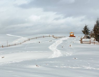 Kış sabah sahne dağ kırsal kar kaplı yol ve kar buldozer üstünde tepe tepe (Ukrayna, Karpat Dağları, huzur huzurlu Dzembronya köy sınırı engellendi)