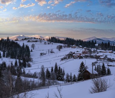 Voronenko, Carpathian, Ukrayna çevresindeki küçük Alp köyü ve kışın ilk gün doğumunda karlı dağlar..