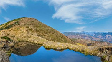 Strymba Dağı 'nda bulutların yansıdığı küçük resimli bir göl. Kolochava köyü yakınlarındaki Karpat Dağları 'nda güzel bir sonbahar günü, Transcarpathia, Ukrayna.