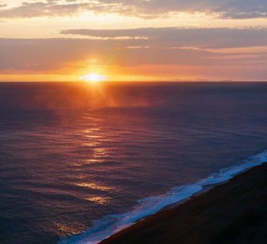 Dyrholaey Burnu, Vik, Güney İzlanda 'dan sonsuz okyanus siyah volkanik kumsal manzarası. Vestmannaeyjar Adaları Ufukta garip siluetler.