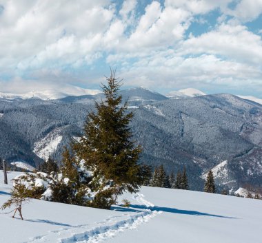 Güzel kış sabah dağ yer kaplayan dağ yolundan görüntüleyin. Skupova dağ yamacı, Ukrayna, görünüme Chornohora ridge üstleri, Karpat.