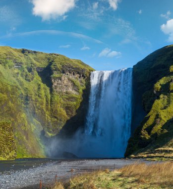 Suyla dolu büyük şelale Skogafoss sonbahar manzaralı, güneybatı İzlanda.