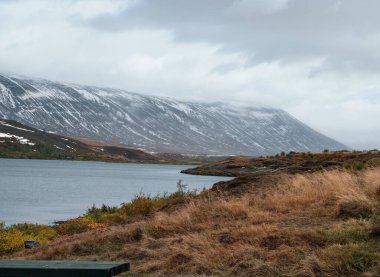 İzlanda 'da otomobil gezisi sırasında görüntüle. Manzaralı İzlanda manzarası: dağlar, fiyortlar, tarlalar, bulutlar, buzullar, şelaleler.