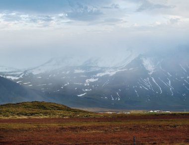 Batı İzlanda Highlands, Snaefellsnes yarımadası, Snaefellsjokull Ulusal Parkı 'ndaki otomobil gezisine bakın. Görkemli volkanik tundra manzarası bulutlarda dağlar.