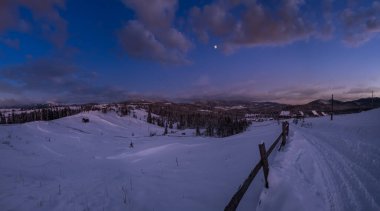 Gece kırsal tepeler, koruluklar ve kışın uzak dağlık dağ köyündeki tarım arazileri. Ukrayna, Voronenko.