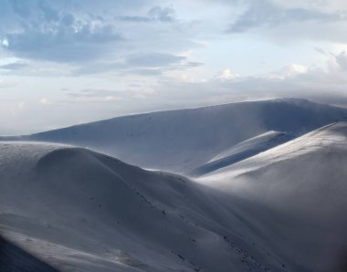 Kar dün akşam güneş ışığında kış dağlarını kapladı. Muhteşem rüzgarlı alacakaranlık.