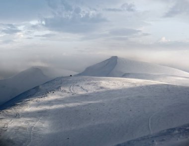 Kar dün akşam güneş ışığında dağ yamacını kapladı. Resimli alp kayak merkezi Dragobrat, Ukrayna, Karpatya Dağları 'nda muhteşem rüzgarlı bir alacakaranlık..