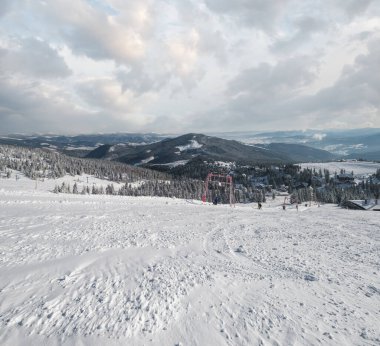 Kış karı dağ kayak merkezi yamacını kapladı. Dragobrat, Ukrayna, Karpat Dağları 'ndaki pitoresk dağlık tatil beldesinde muhteşem güneşli bir gün. İnsanlar tanınmaz halde..