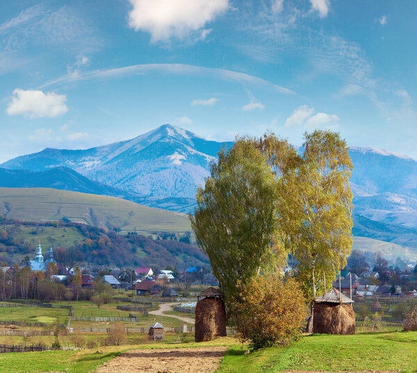Autumn mountain village outskirts with stack of hay and country dirty road (Kolochava, Carpathian Mt's, Ukraine).
