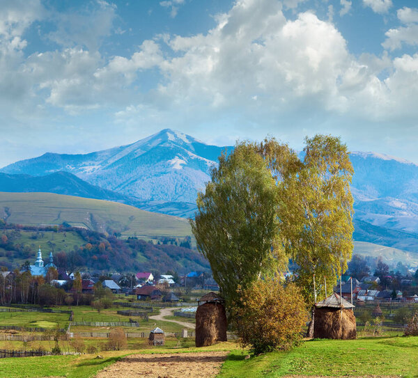 Autumn mountain village outskirts with stack of hay and country dirty road (Kolochava, Carpathian Mt's, Ukraine).