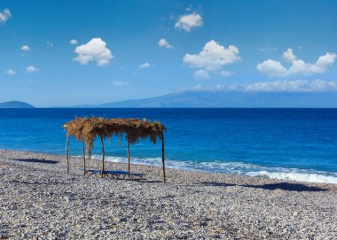 Şezlong ve gölgelik ile Yaz sabahı çakıl plaj (Borsh, Arnavutluk).