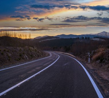 Asphalt road curve and autumn sunset Mountains, Ukraine, Carpathian. clipart