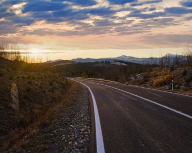 Asfalt yol eğrisi ve sonbahar günbatımı Dağlar, Ukrayna, Karpatlar.