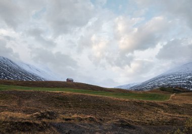 İzlanda 'daki otomobil gezisi sırasında güzel bir dağ manzarası. Manzaralı İzlanda manzarası: dağlar, tarlalar, bulutlar, buzullar, kayalar.