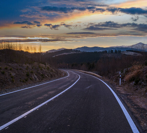 Асфальтовая дорога и осенний закат Горы, Украина, Карпаты.
