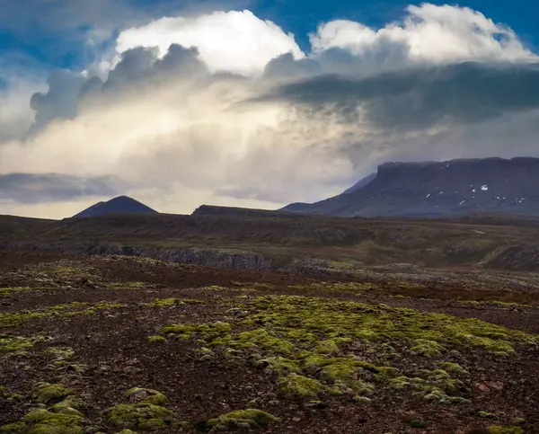 View during auto trip in West Iceland highlands, Snaefellsnes peninsula, Snaefellsjokull National Park. Spectacular volcanic tundra landscape with mountains, craters, lakes, gravel roads.