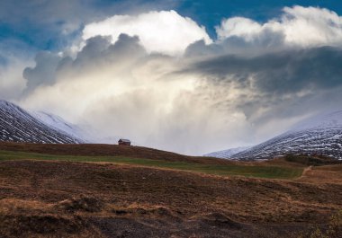 İzlanda 'daki otomobil gezisi sırasında güzel bir dağ manzarası. Manzaralı İzlanda manzarası: dağlar, tarlalar, bulutlar, buzullar, kayalar.