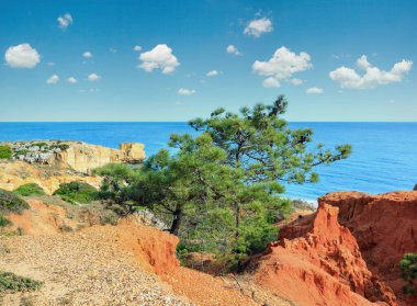 Praia de Sao Rafael, Albufeira, Algarve, Portekiz yakınlarındaki kırmızı kireçtaşı ve kırmızı kireçtaşı kayalıkları ile Atlantik yaz manzarası.