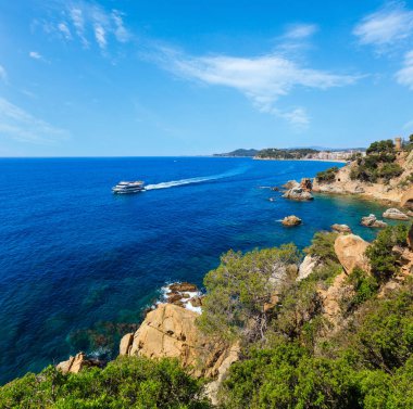 Yaz denizi kayalık kıyı manzarası ile Sant Joan Kalesi ve tekne (Lloret de Mar town, Katalonya, İspanya).