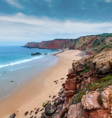 Amado Beach bulutlu görünüm ile renkli uçurumlar, Algarve, Portekiz.