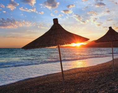 Yaz günbatımı plaj strawy şemsiye (Arnavutluk ile).