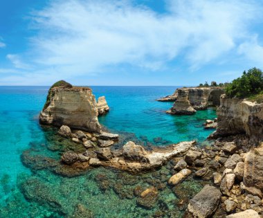 Kayalıklı, kayalık kemerli (faraglioni), Torre Sant Andrea, Salento deniz kıyısı, Puglia, İtalya. İki dikiş panoraması. İnsanlar tanınmaz halde..