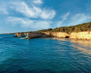 Güzel gündoğumu deniz manzarası ile beyaz kayalık uçurum, deniz defne, adacıkları ve faraglioni Spiaggia della Punticeddha plajda,: Salento Adriyatik Denizi kıyısında, Puglia, İtalya.