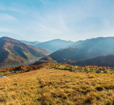 Sonbahar Karpat Dağları yatay, çok renkli sarı-turuncu-kırmızı-kahverengi ağaçta yamaç ve Rakhiv şehir ve Tysa Nehri kadar aşağıda (görünümünden Rakhiv pass, Transcarpathia, Ukrayna).