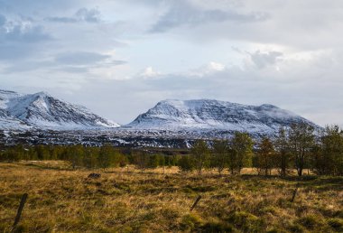 Kuzey İzlanda 'daki otomobil gezisi sırasında güzel bir dağ manzarası. Manzaralı İzlanda manzarası: dağlar, tarlalar, bulutlar, buzullar, kayalar, ağaçlar.