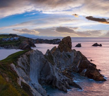Portio Beach (Pielagos, Cantabria, İspanya yakınındaki günbatımı Atlantik Okyanusu kayalık sahil şeridi).