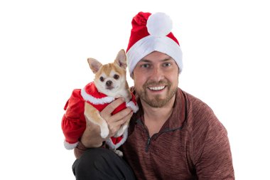 Beyaz bir arka planda izole edilmiş Noel şapkası ve elbisesi olan bir adam ve köpek yavrusu.