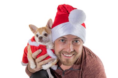 Beyaz bir arka planda izole edilmiş Noel şapkası ve elbisesi olan bir adam ve köpek yavrusu.