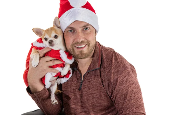Beyaz bir arka planda izole edilmiş Noel şapkası ve elbisesi olan bir adam ve köpek yavrusu.
