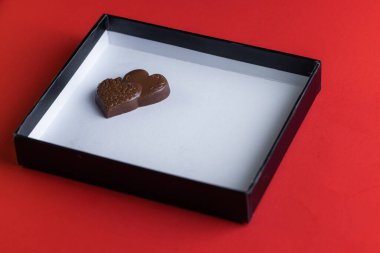 heart shaped ring with chocolates inside of a white lid with red all around