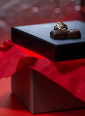 heart shaped ring with chocolates on a black box lid
