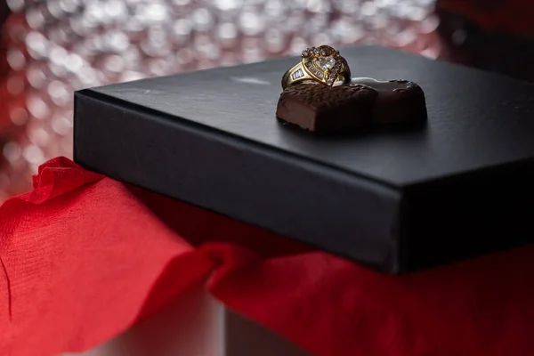 ハート型のリングにブラックボックスの蓋にチョコレート — ストック写真
