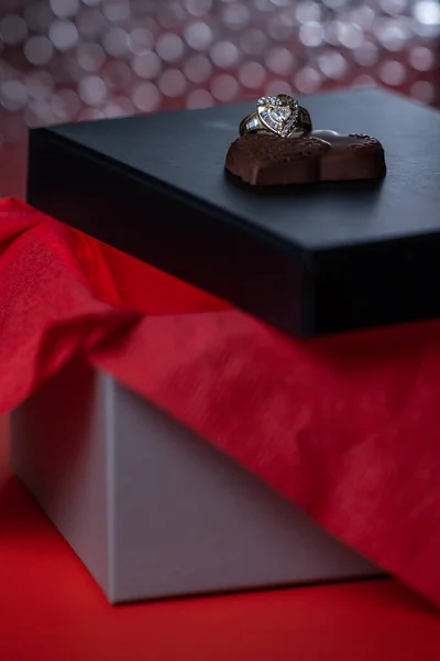 ハート型のリングにブラックボックスの蓋にチョコレート — ストック写真