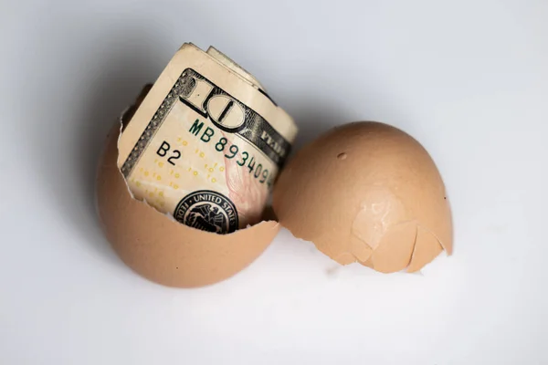 Beyaz Arka Planda Kırılmış Bir Yumurtanın Içinde Dolarlık Banknot Kullanarak — Stok fotoğraf