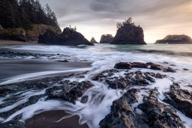 Beautiful Secret Beach in the Samuel H Boardman Scenic Corridor along the Oregon Coast at sunset with a faint glow on the rocks