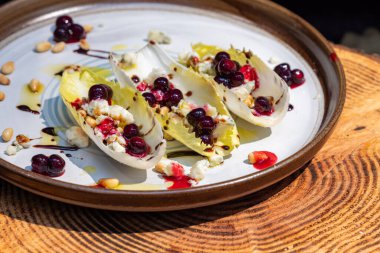 Taze Belçika hindiba dalışı tekneleriyle yapılmış vejetaryen aperatifleri kızarmış çam fıstığı, bleu peyniri, taze yaban mersini ve balzamik çiselemeli taze zeytin yağı ile doldurulmuş..