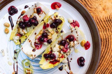 Taze Belçika hindiba dalışı tekneleriyle yapılmış vejetaryen aperatifleri kızarmış çam fıstığı, bleu peyniri, taze yaban mersini ve balzamik çiselemeli taze zeytin yağı ile doldurulmuş..